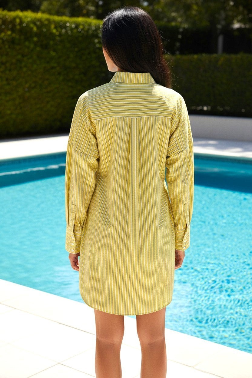 State of Georgia yellow and white striped linen-blend shirt dress on a woman standing by a pool.